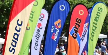Colorful teardrop flags waving at an outdoor event.
