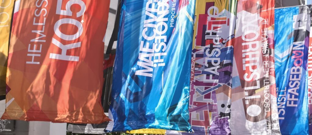 Printed banners hanging outdoors, bright colors.