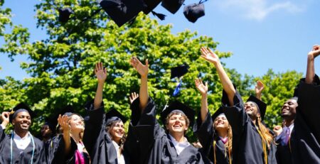 Graduates celebrating outdoors, happy and smiling