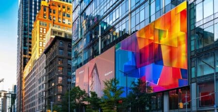 a vibrant urban backdrop showcases a large, glossy vinyl banner prominently displayed on a building, illustrating various sizes and material options with bold graphics, highlighting its suitability for both indoor and outdoor environments.