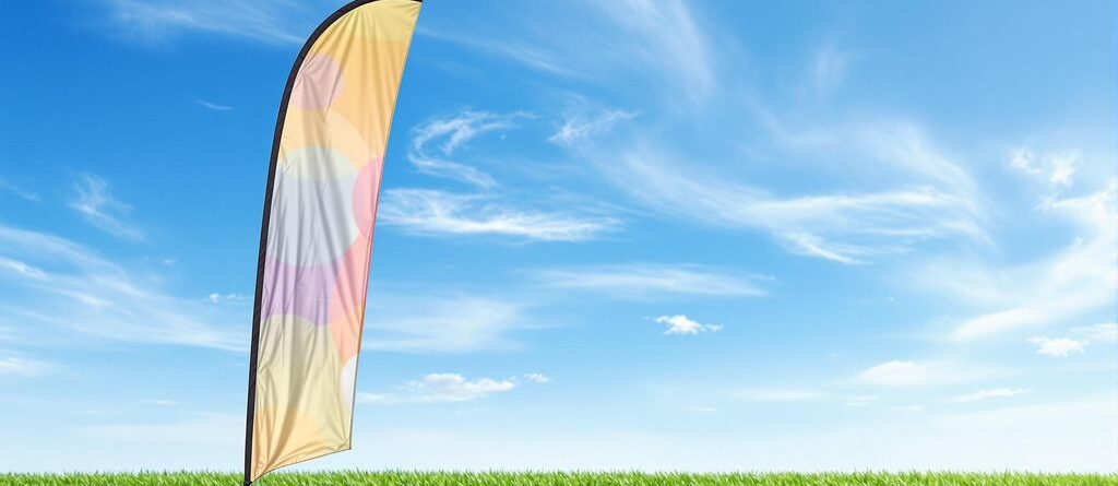 Bandera de lágrima para exteriores, tela vibrante, cielo despejado, hierba verde.