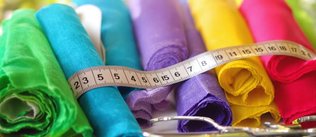Rolls of colorful fabric, a measuring tape, and scissors.