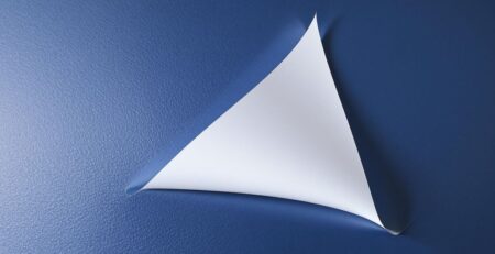 Removable vinyl material peeling off a clean surface.