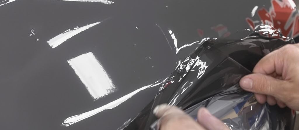 Aplicando vinilo adhesivo a un coche.