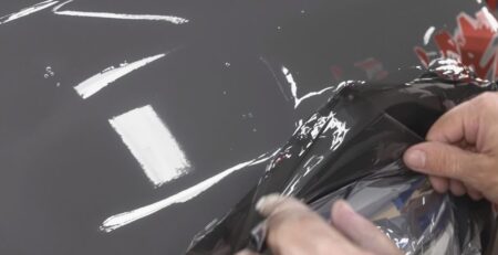 Applying vinyl wrap to a car.