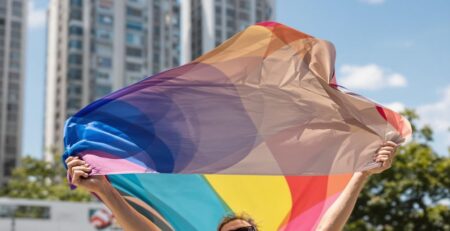 Man holding large colorful banner outdoors
