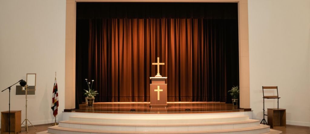 Escenario de iglesia bien iluminado con una decoración sencilla y moderna.
