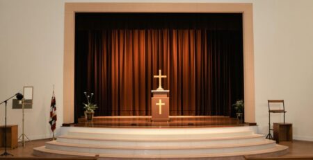 Escenario de iglesia bien iluminado con una decoración sencilla y moderna.