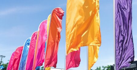 Colorful feather flags outdoors, waving in a sunny breeze.