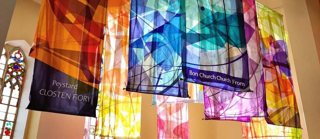 Colorful church banners, light streaming in.